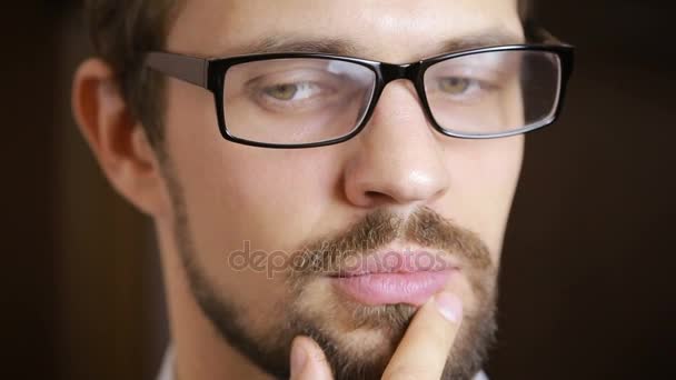 close-up of beautiful green-eyed man with a beard wearing glasses - Imágenes, Vídeo