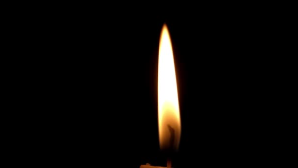 eine brennende gelbe Kerze mit blinkender Flamme in der Nacht. - Filmmaterial, Video