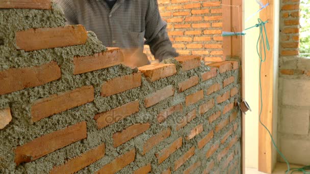 Εργαζόμενος κατασκευή τοίχο από τούβλα στο εργοτάξιο - Πλάνα, βίντεο