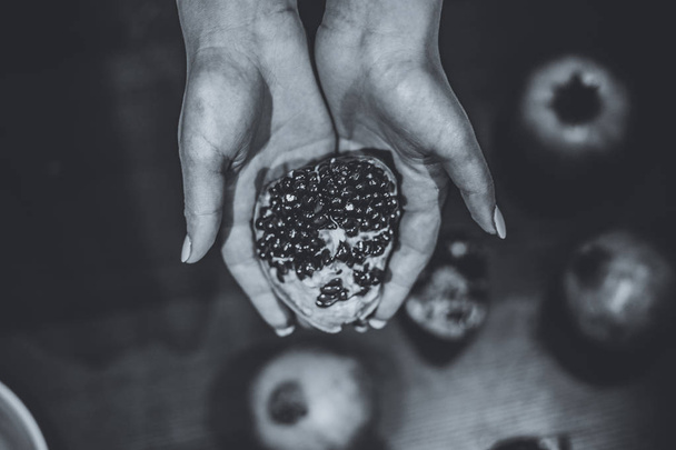 Pomegranate fruit on the woman's hands - 写真・画像