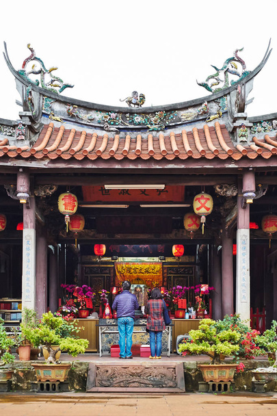 People pray for god in traditional oriental heritage temple in Taiwan (Chinese Translation on lantern : Jen-wen Academy, on board : improve the society by education - Foto, afbeelding