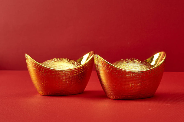 Gold ingot on a red background - Foto, afbeelding