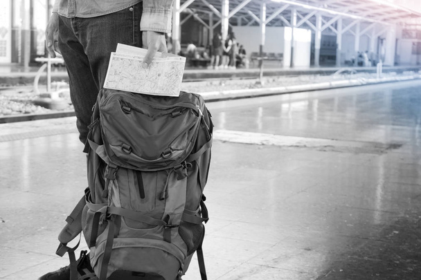 Uzun bir yolculuk seyahat sırt çantası ile tren istasyonunda bekleyen backpacker. Seyahat konsepti ile siyah beyaz filtre etkilenir. - Fotoğraf, Görsel