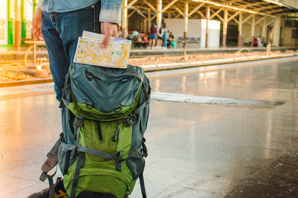 Backpacker czeka długa podróż na dworzec kolejowy z plecaka. Koncepcja podróży z czarno-białych filtr dokonane. - Zdjęcie, obraz