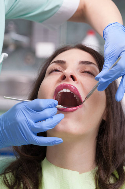 Dentist curing a female patient - Foto, Imagen