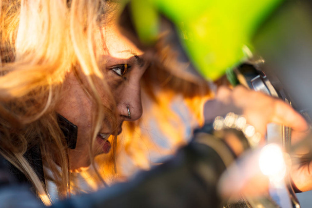 γυναίκα ρύθμιση της μοτοσικλέτας για την εκτέλεση - Φωτογραφία, εικόνα