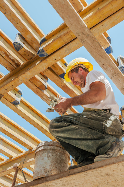 Trabajador de la construcción sonriente ocupado bajo vigas de encofrado de losa
 - Foto, Imagen