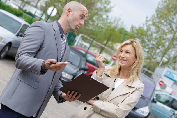 atractivo vendedor mostrando coche nuevo a un cliente
 - Foto, imagen