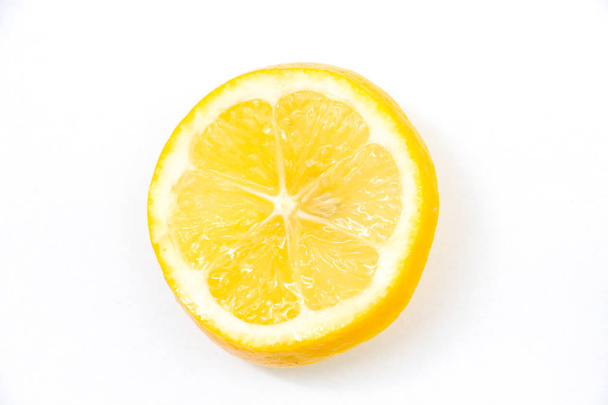 Juicy yellow slice of lemon on a white background isolated - Foto, afbeelding