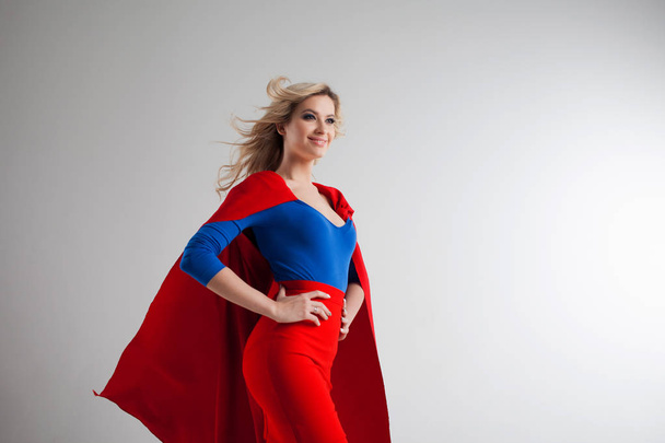 Superhero Woman. Young and beautiful blonde in image of superheroine in red Cape growing - Foto, afbeelding