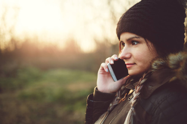 Mujer joven llamando con teléfono móvil al aire libre en invierno
 - Foto, Imagen