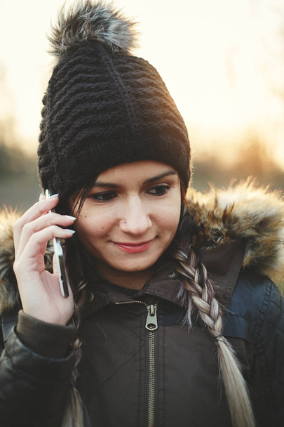 Young woman calling with mobile phone outdoors in winter - Foto, Imagen