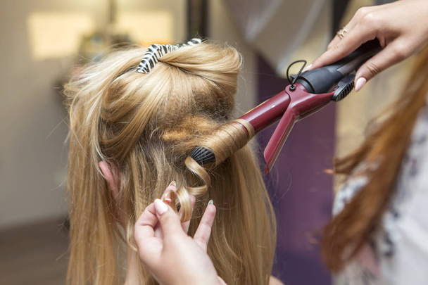 Μελαχρινή κόκκινα μαλλιά καλλιτέχνης κομμωτής κάνοντας σγουρά hairstyle β - Φωτογραφία, εικόνα