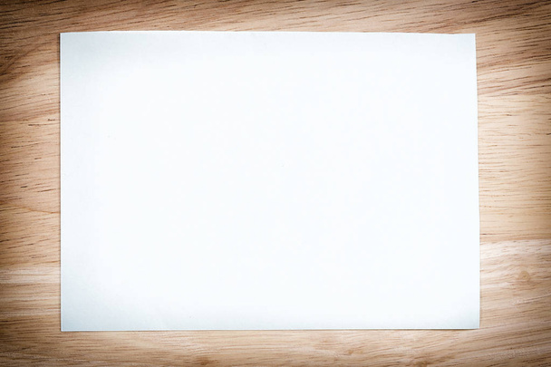 White paper blank on the brown wooden floor of vintage color. - Φωτογραφία, εικόνα