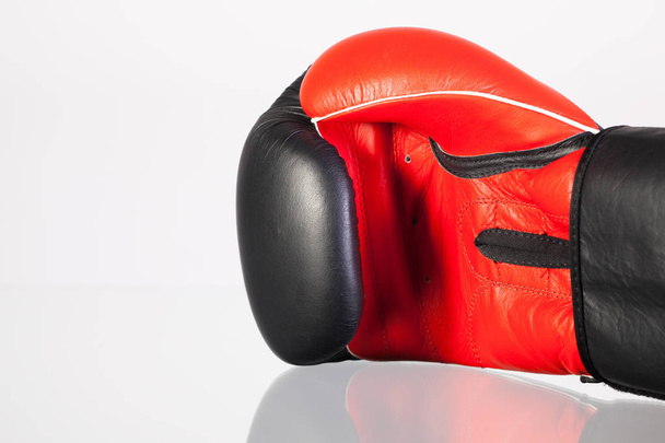Red and black boxing gloves on a glass table  - Photo, image