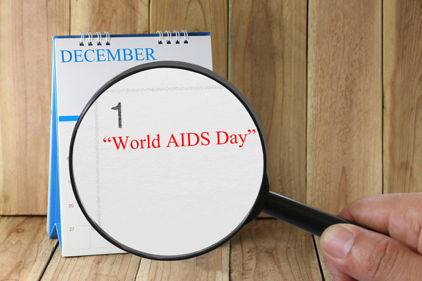 Увеличительное стекло в руке на календаре вы можете посмотреть текст World AID
 - Фото, изображение
