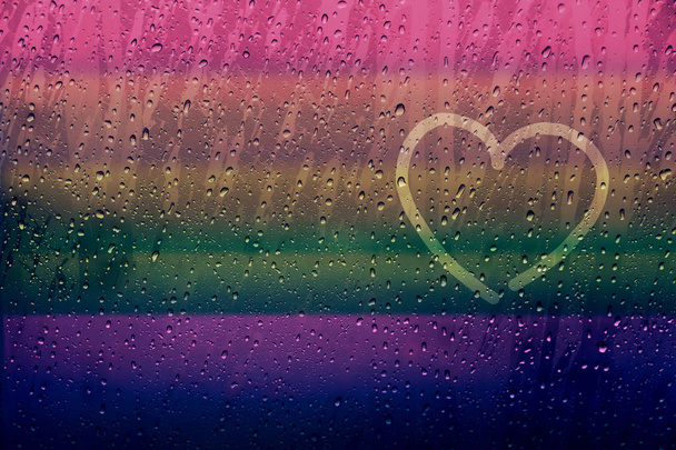 Forma de corazón solitario dibujado en la ventana de cristal con el color del arco iris y
  - Foto, Imagen
