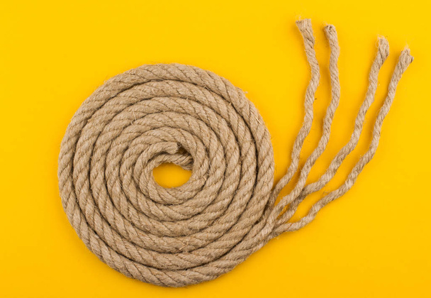 top view of rope spiral with unraveled end on yellow background - Photo, Image