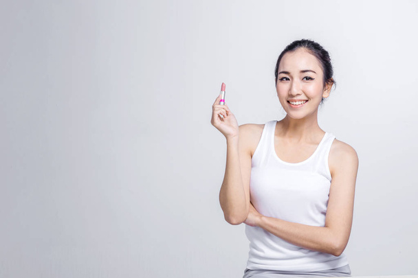 Beautiful asian girl applying lipstick studio shoot with white background - Фото, изображение