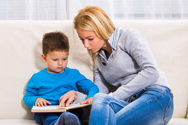 Mother and son reading book together - Foto, Bild