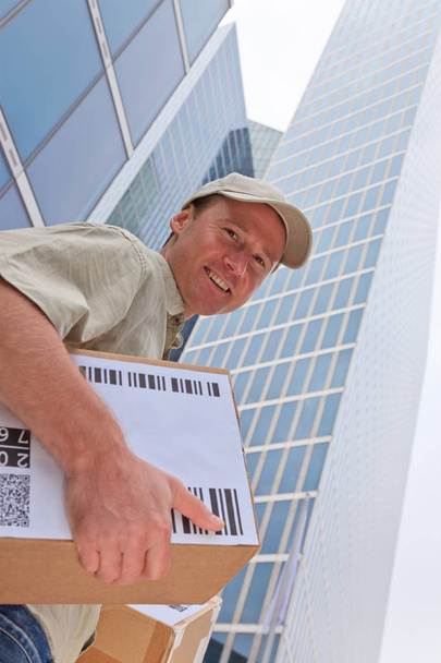Delivery Boy Standing In Front Of Modern Buildings - Photo, Image