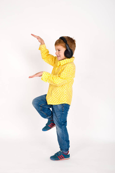 de jongen in oortelefoons luistert naar muziek en Dancing - Foto, afbeelding