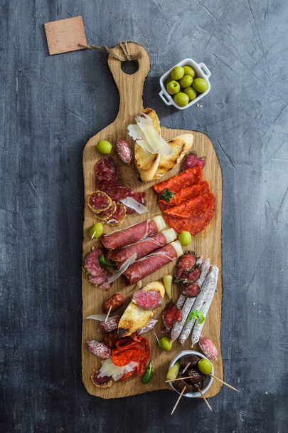 Різні іспанські ему на столі: джемон, хорізо, салямі, сир і вино. Вид зверху
 - Фото, зображення