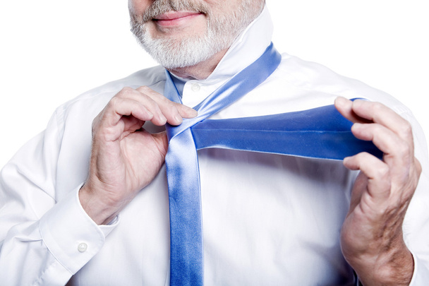 Мужчина старшеклассник одевается, завязывая галстук
 - Фото, изображение