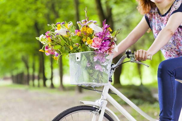 woman holding a vintage bicycle with flowers  - Fotó, kép