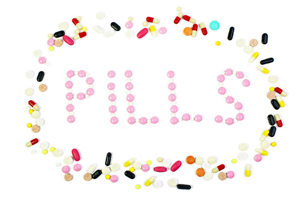 Group of colorful pills with "pills" word isolated on white - Fotó, kép