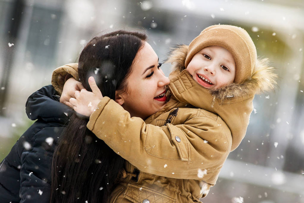 Happy mother and baby in winter park. Family outdoors. - Photo, Image
