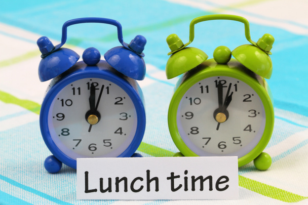Lunch time card with two miniature clocks showing twelve and one o'clock - Photo, Image