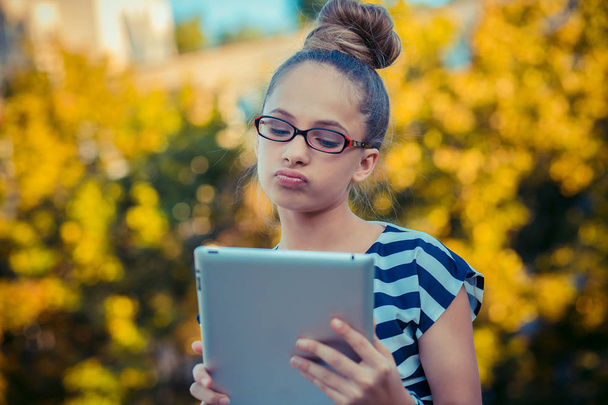Verärgert traurig skeptisch unglücklich ernstes Mädchen mit Handy-Pad-Computer - Foto, Bild