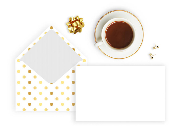 Flat lag. Witte achtergrond, envelop patroon polka goud, koffiekopje en potlood. Bedrijfsdesktop. Uitnodiging mockup. - Foto, afbeelding
