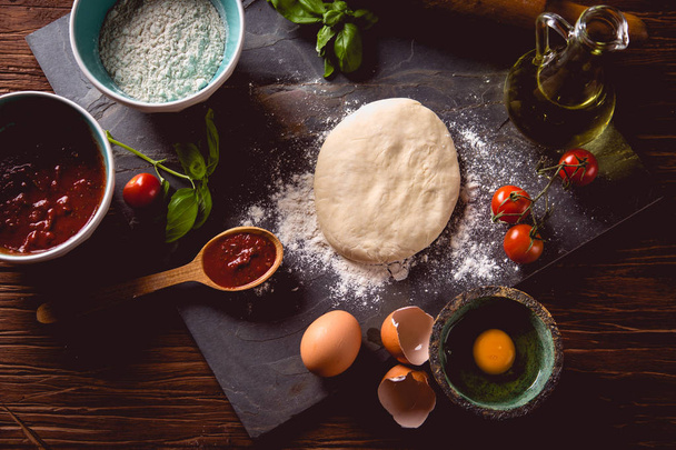 Dough with flour on wooden table, preparing homemade pizza - Fotografie, Obrázek