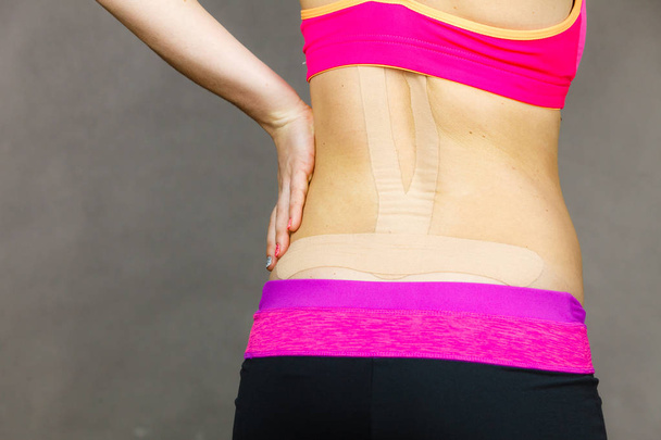 Woman with medical kinesio taping on back - Foto, imagen