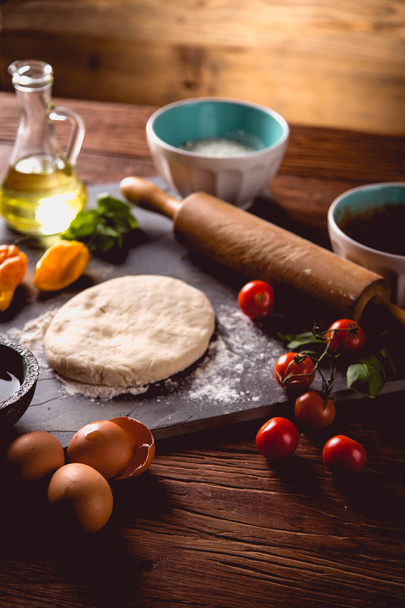 Fresh and tasty homemade pizza on wooden table with ingredients - Foto, imagen