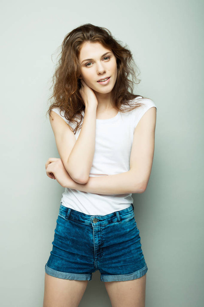 lifestyle, fashion and people concept: young curly woman posing in studio - Φωτογραφία, εικόνα