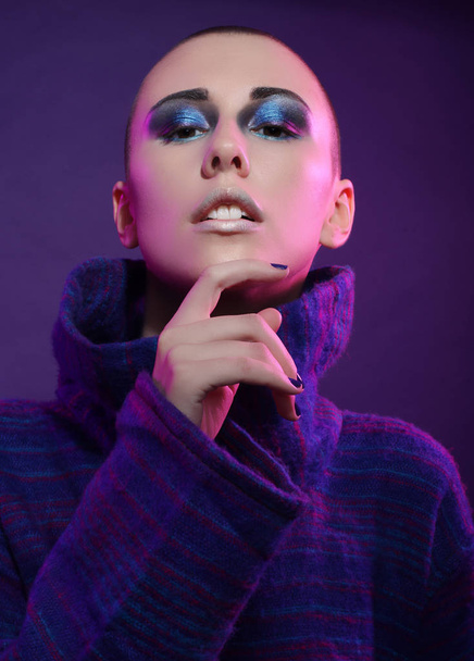 Young fashion model posing in studio. Bald. Bright make up. - Photo, Image