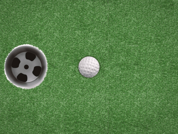 мяч для гольфа с чашкой для гольфа на зеленом фоне
 - Фото, изображение