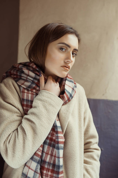 Lovely brunette model  in coat posing in the passage - Photo, Image