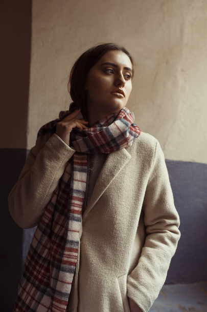 Fashionable brunette model  in scarf posing in the passage - Foto, Imagem