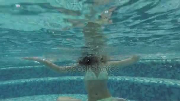 Dospívající dívka pod vodou v bazénu v lotosové pozici - Záběry, video
