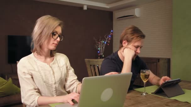Νεαρό ζευγάρι χρησιμοποιούν τις συσκευές τους Ψηφιακή περιήγηση στο διαδίκτυο - Πλάνα, βίντεο
