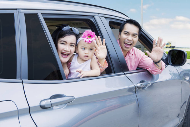 Cheerful family waving hands in the car - Foto, imagen