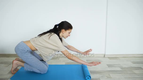 Young woman doing yoga exercise - opening her yoga mat - Кадри, відео