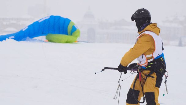 Snowkiting-cursussen in de sneeuw op de bevroren rivier, kite surfer klaar voor schuifdeuren - Foto, afbeelding