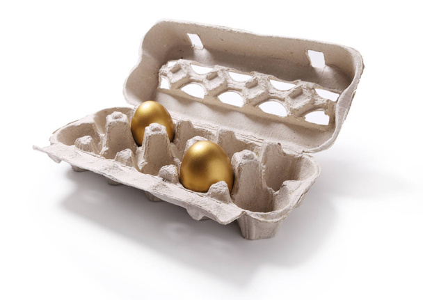 Bild von Pappschachtel mit zwei goldenen Eiern isoliert auf weißem Ba - Foto, Bild