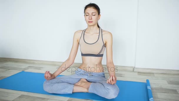 Mujer joven haciendo ejercicio de yoga parada y probando su resistencia
 - Metraje, vídeo