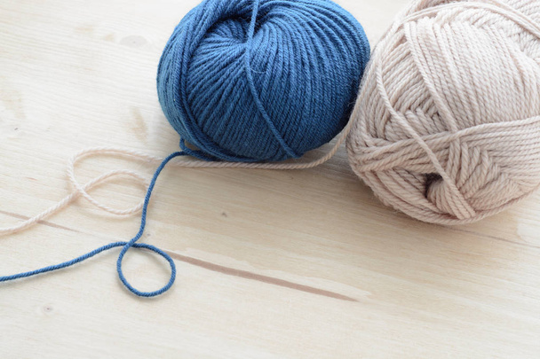 Pinces à tricoter bleu et beige sur table en bois
 - Photo, image